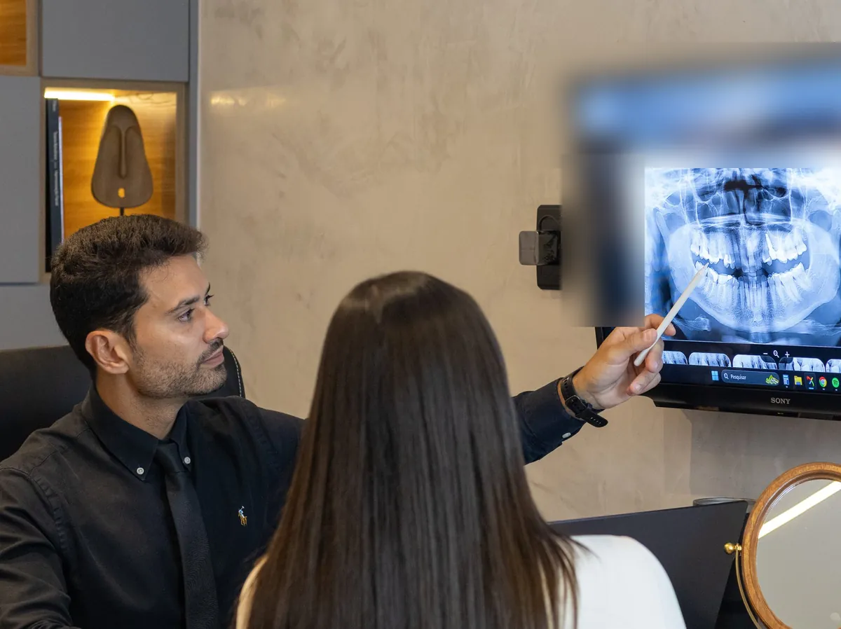 Doutor Ygor Almeida explicando uma radiografia panorâmica a uma paciente
